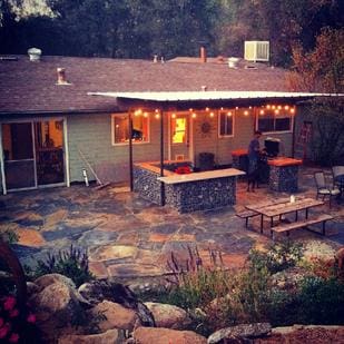 A backyard with a grill and table in it