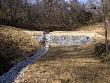 A small stream of water flowing through the middle of a field.