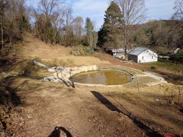 A pond that is in the middle of a field.