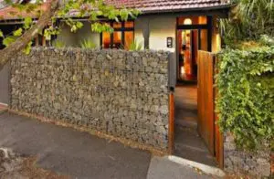 a house Gabion Fence with an open door