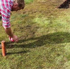 A man in plaid shirt playing with an orange object.