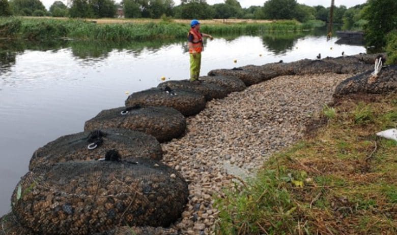 A person standing on rocks near water.